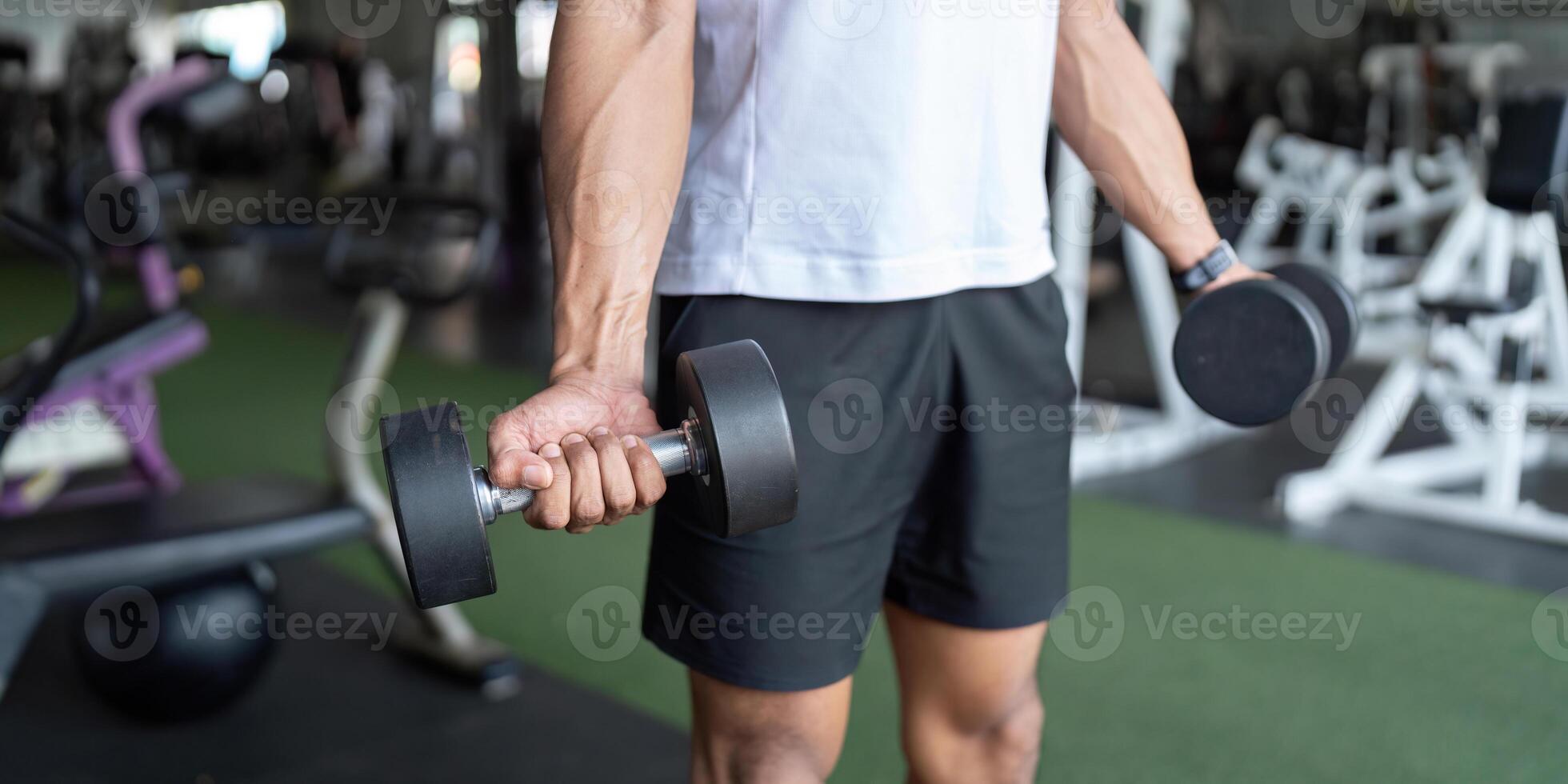 Dumbbell Workout. Man lifting weights in gym for strength training. photo