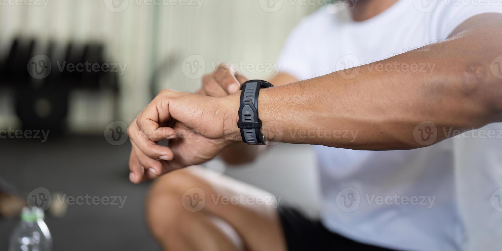 Fitness Tracking. Man checking smartwatch while resting after workout. photo
