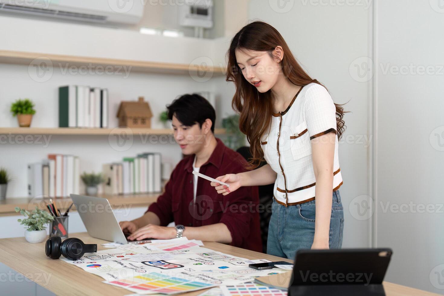 Design Collaboration. Young woman and man discussing UX UI concepts in a modern office. photo