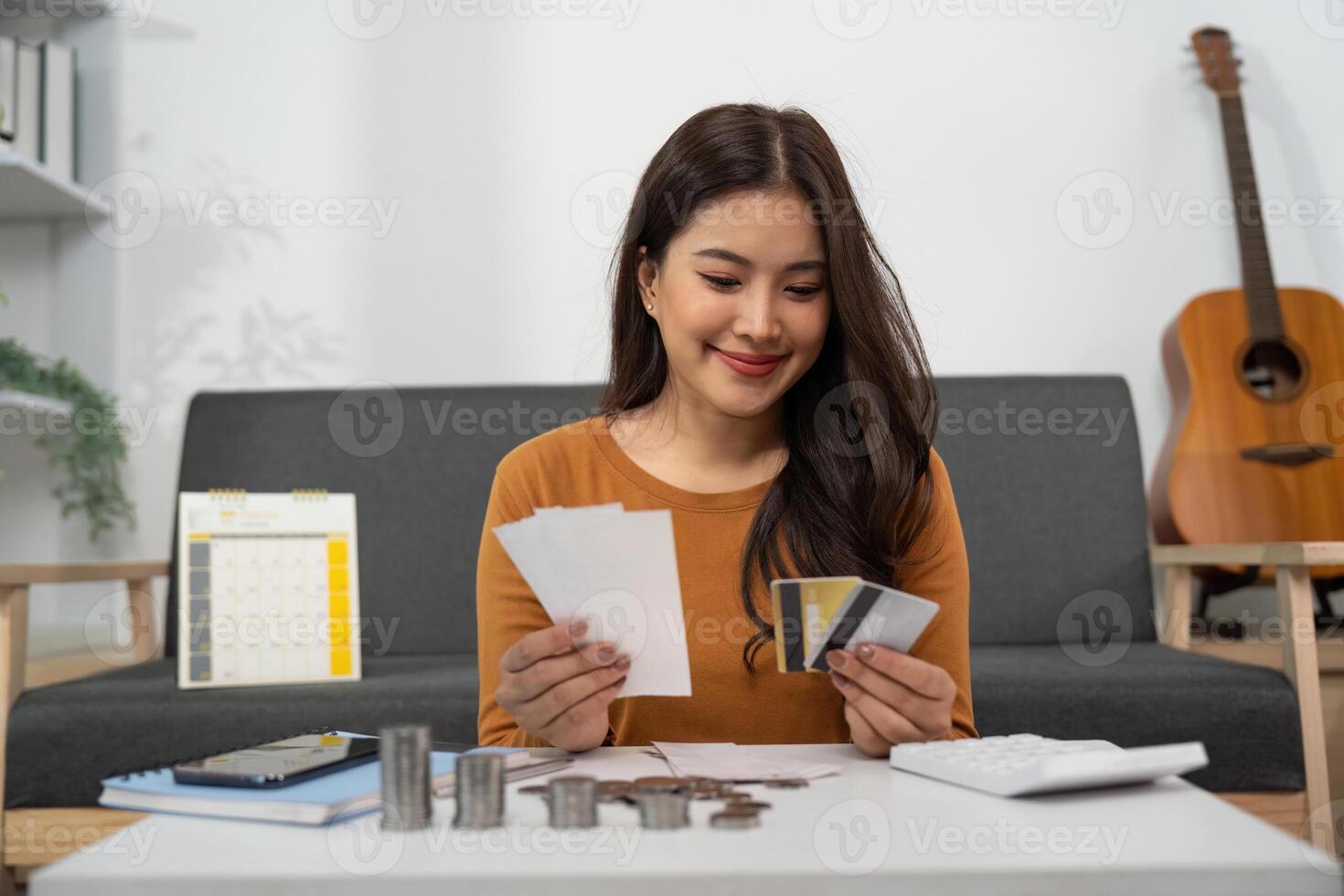 Budgeting and Financial Planning. Woman smiling while reviewing receipts and credit cards. photo