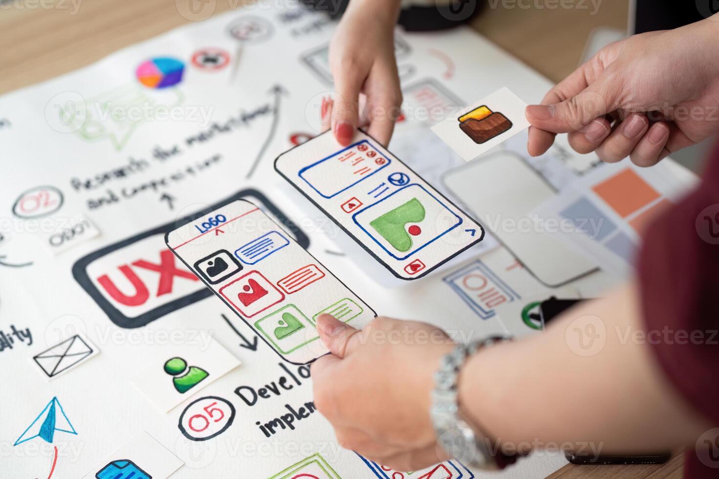 Collaborative UX Design. Team members discussing user interface elements on design board. photo