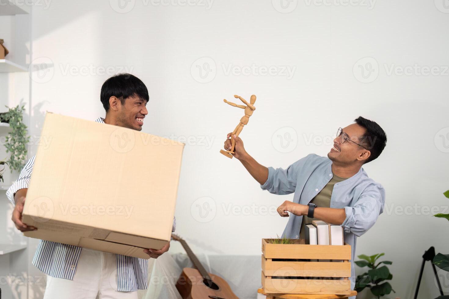 Happy gay couple sharing a moment while unpacking their new home photo