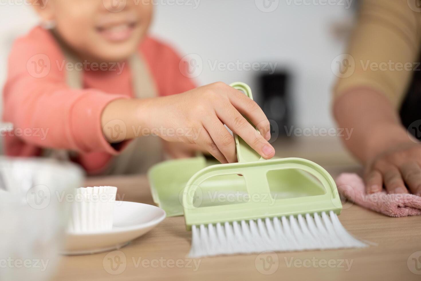 Family Cleaning Time. A child enthusiastically helps with kitchen cleaning tasks. photo