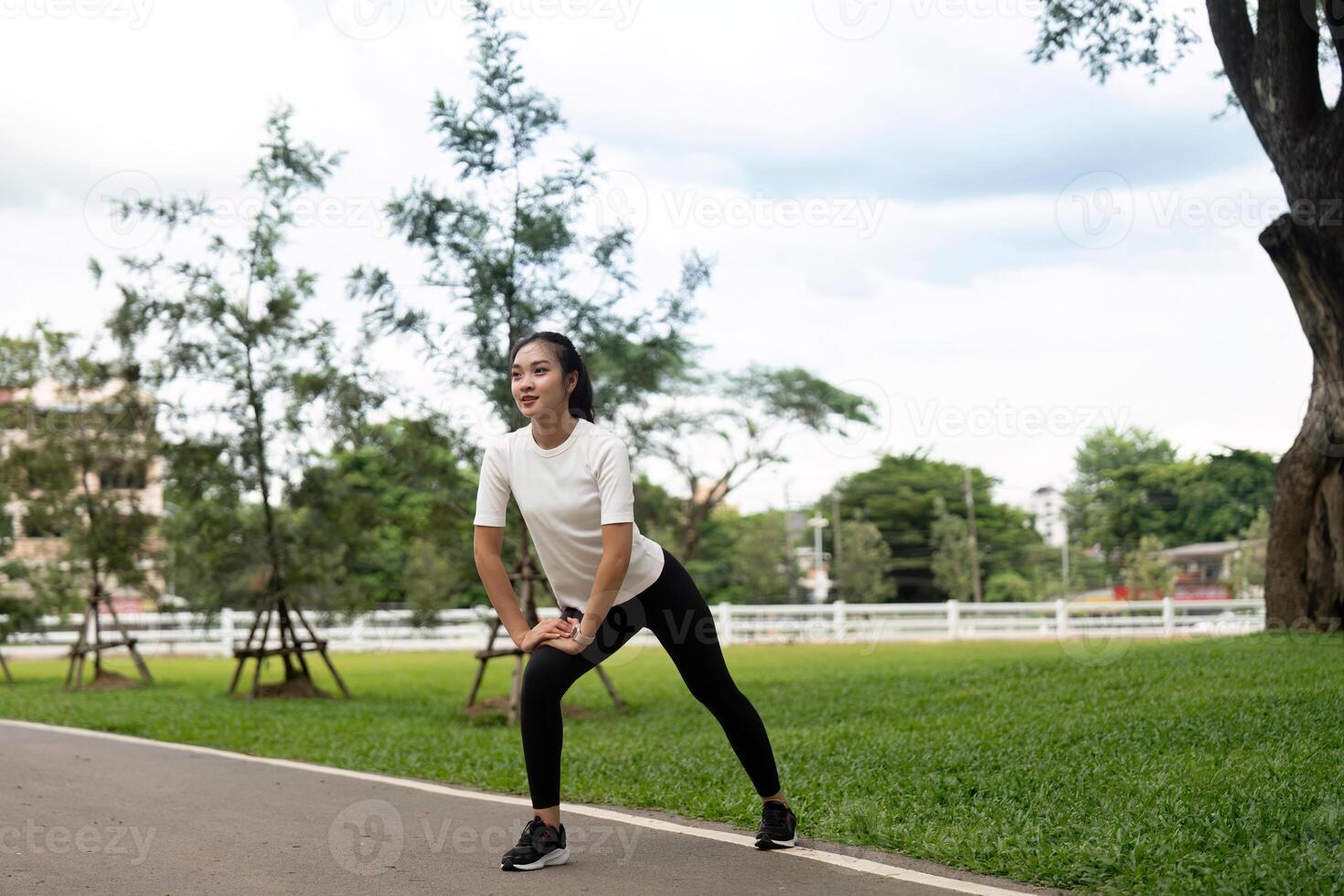 Dynamic Stretching. Young woman practicing lunges in a park for fitness preparation. photo