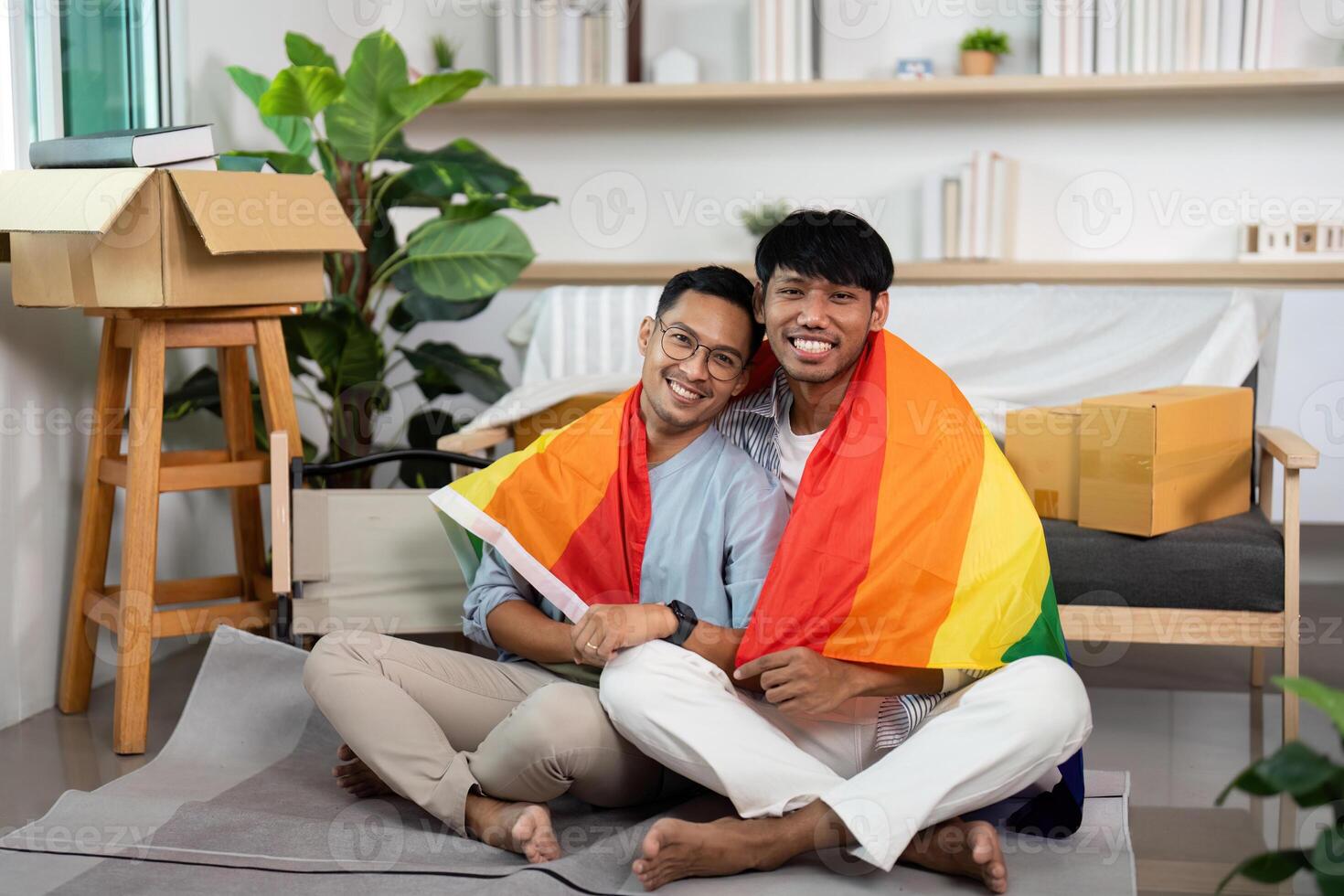 LGBT couple embracing with pride flag in their cozy new home photo