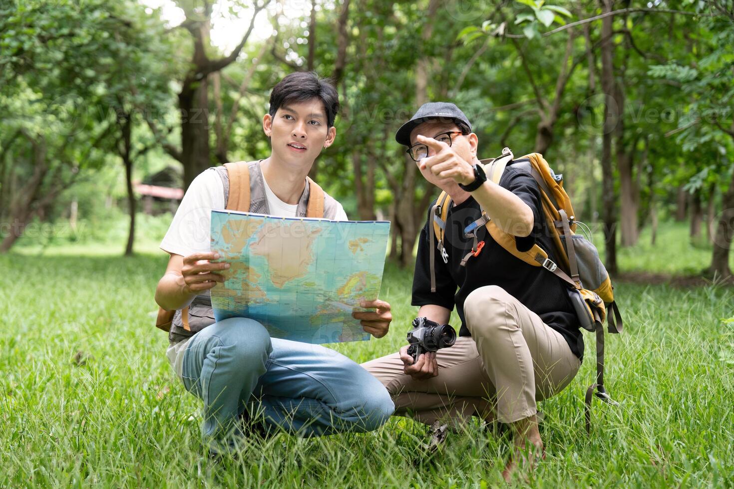 Father and Son Hiking Adventure. Exploring nature with a map in the forest. photo
