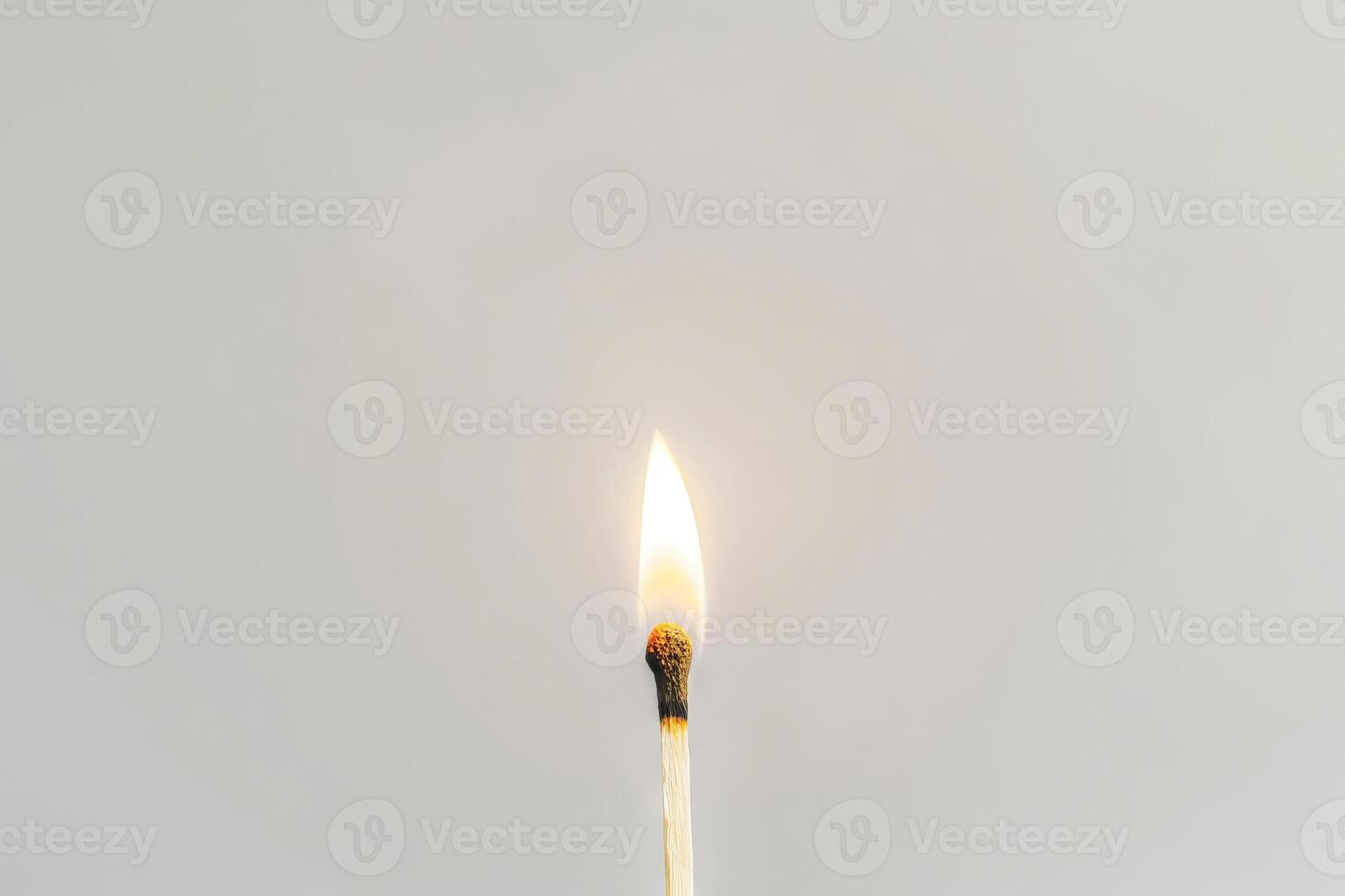 Single burning matchstick against white background. Concept of ignition, heat, energy, simplicity, and minimalism. Copy space photo