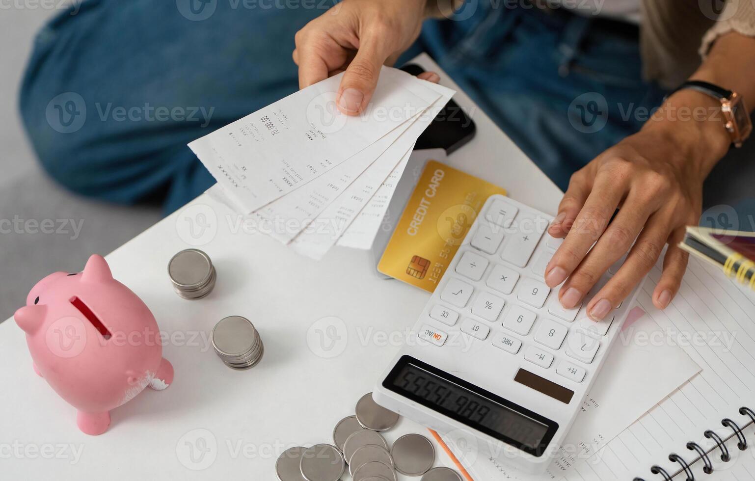Financial Planning. Individual calculating expenses with receipts and a calculator. photo