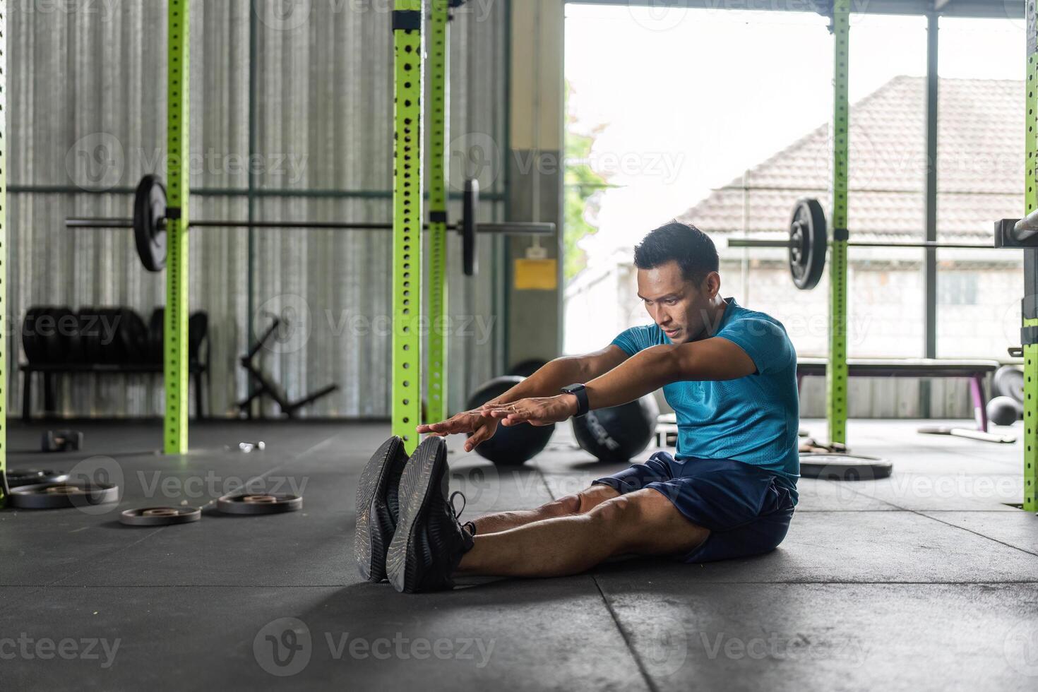 Fitness Stretch. Man reaching forward in a gym for flexibility. photo