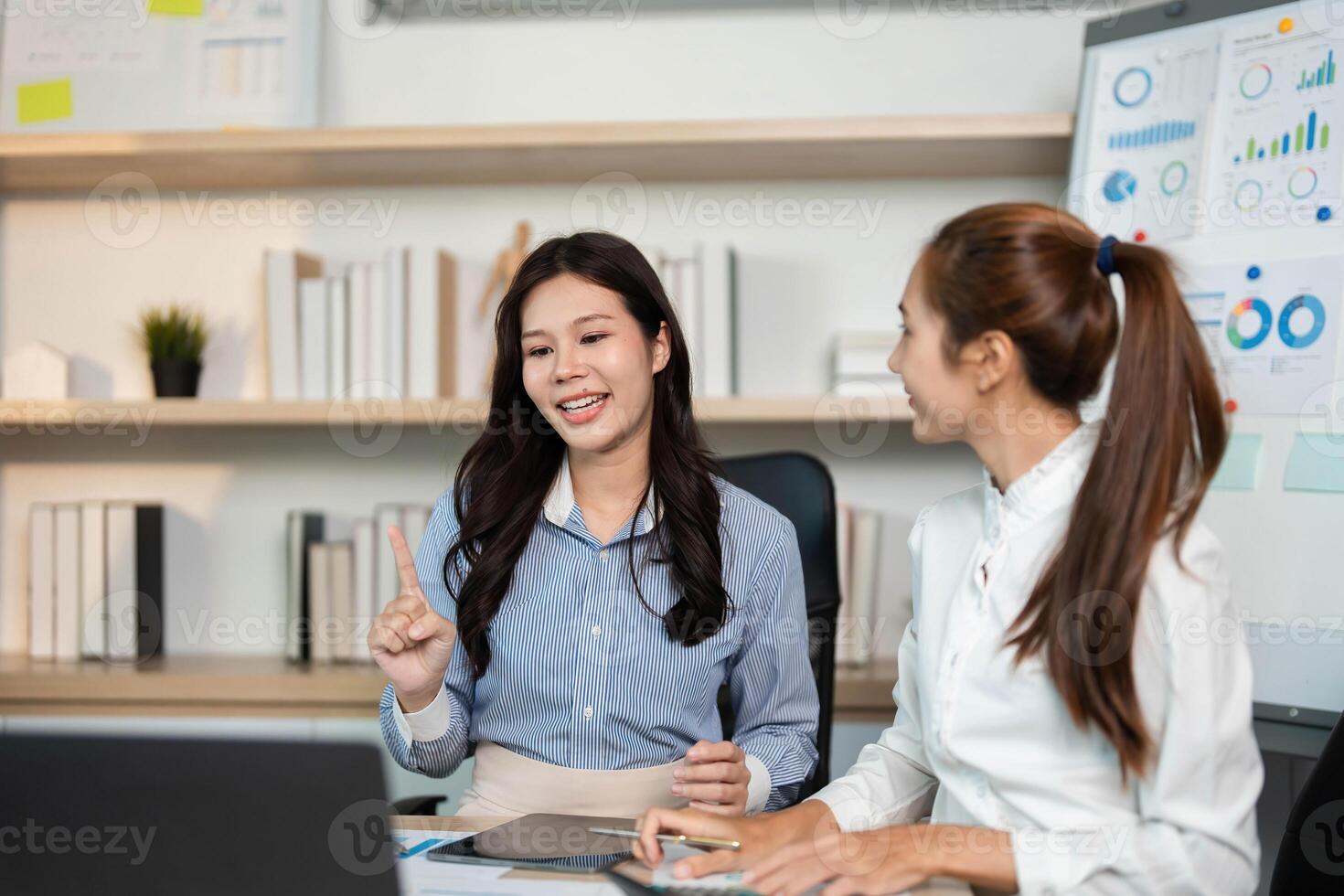 Engaging Financial Discussion. Two women collaborating on business strategies in an office setting. photo