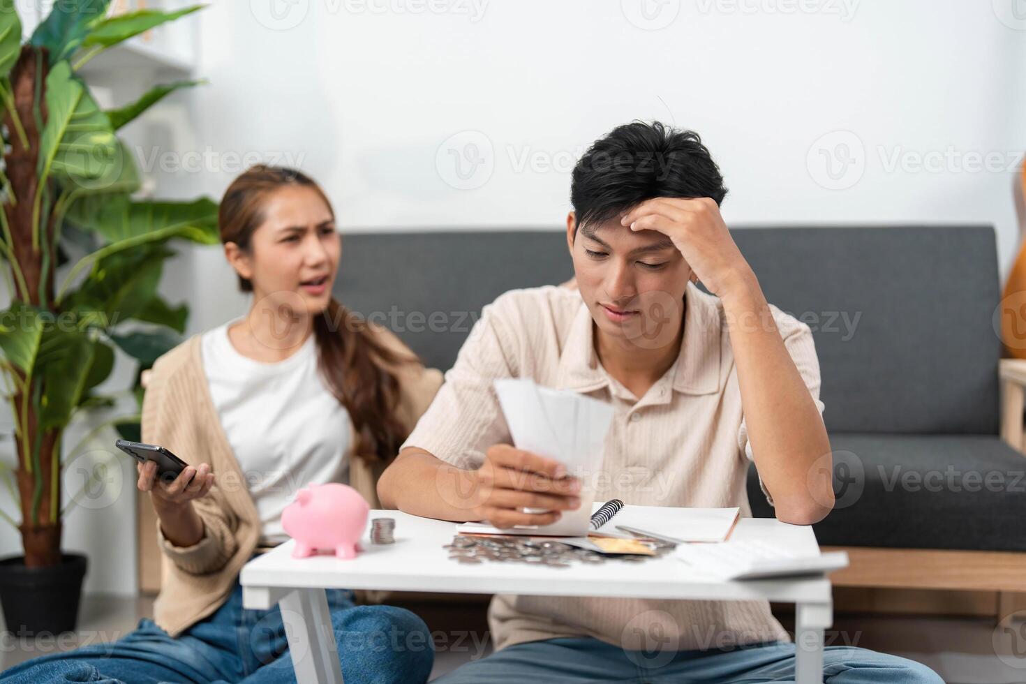 Financial Planning. Couple arguing over bills and budgeting while using smartphone. photo