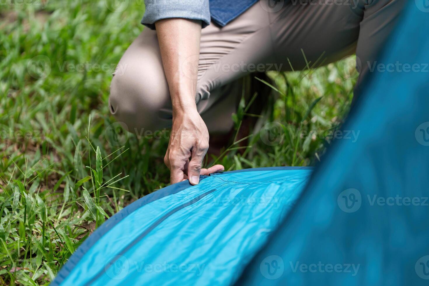 Family camping experience. Close-up of hands setting up a tent. photo