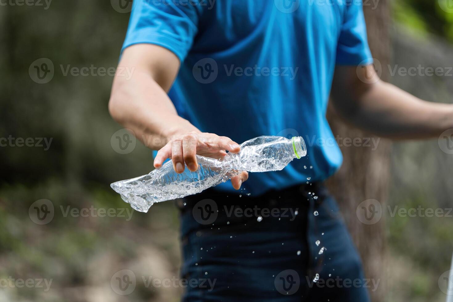 Volunteer in action. Individual splashing water while discarding plastic bottle. photo