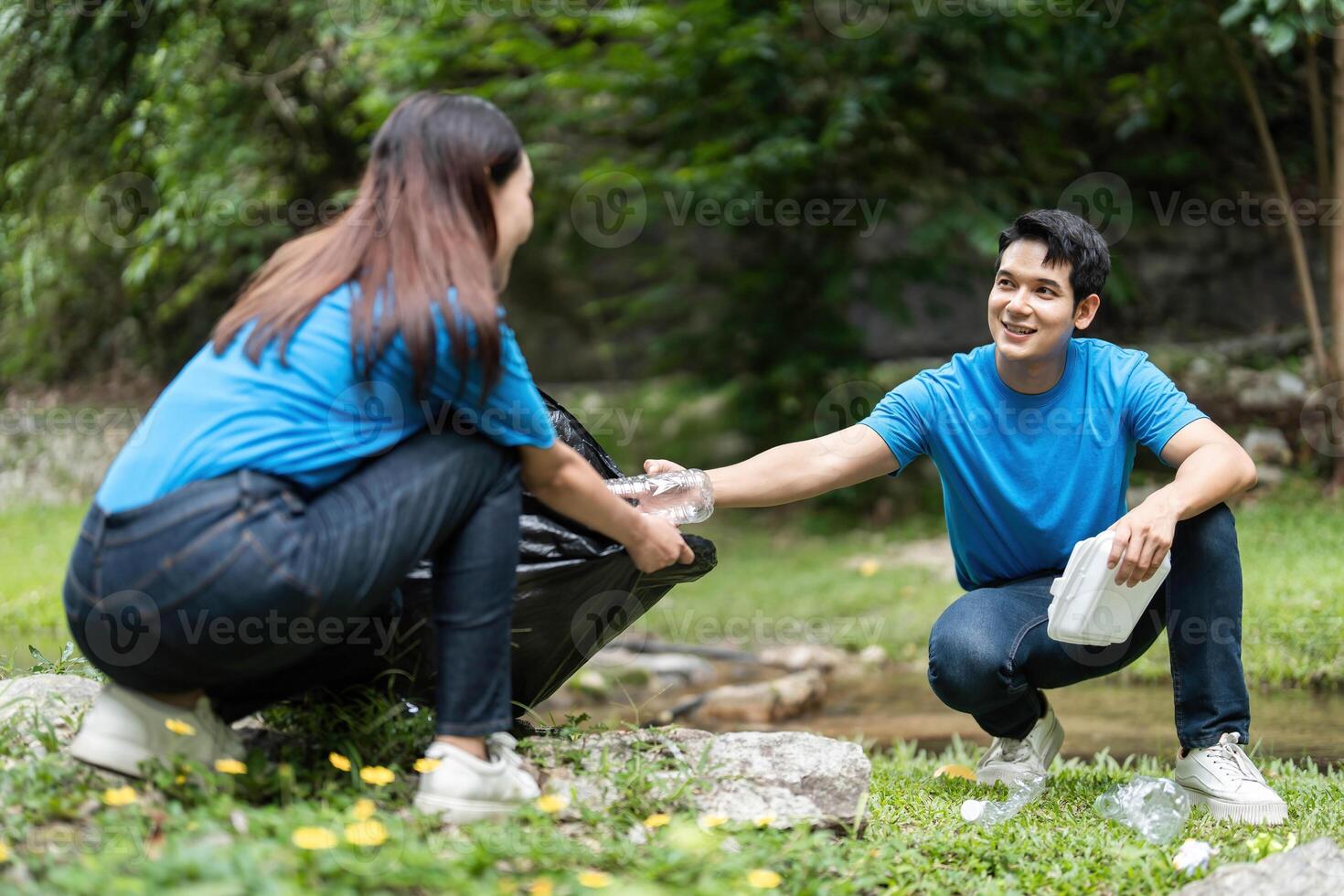 Volunteer Team Collecting Waste in Nature. Two individuals working together to promote environmental responsibility. photo