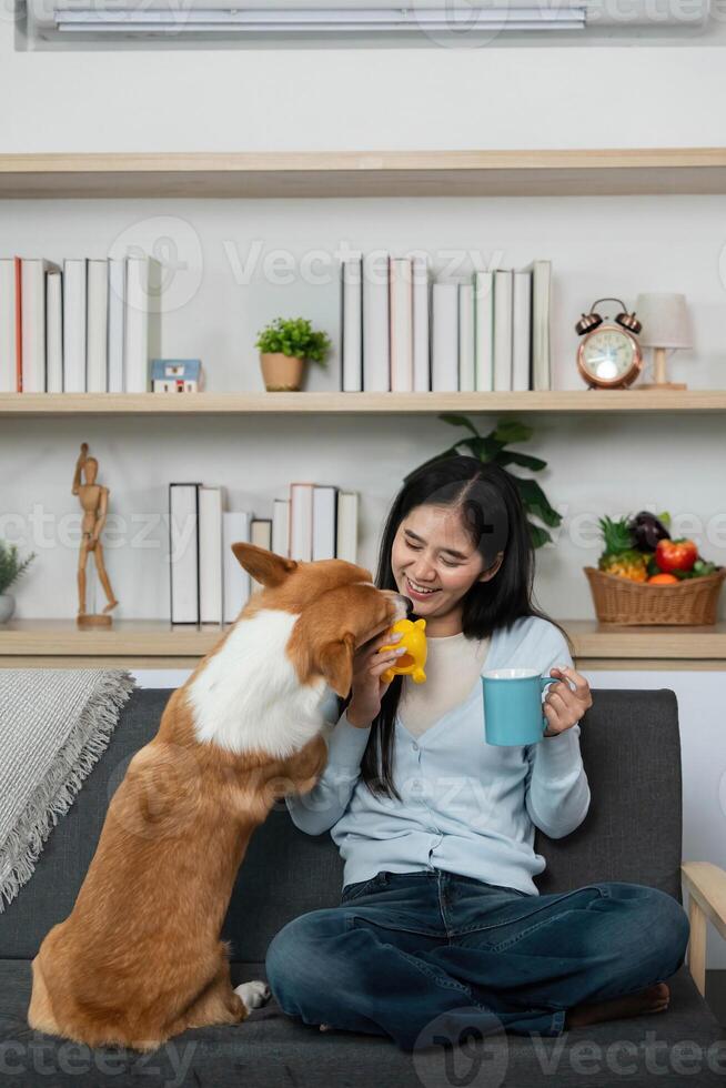 Quality Time with Pet. Woman enjoying coffee while playing with her dog at home. photo