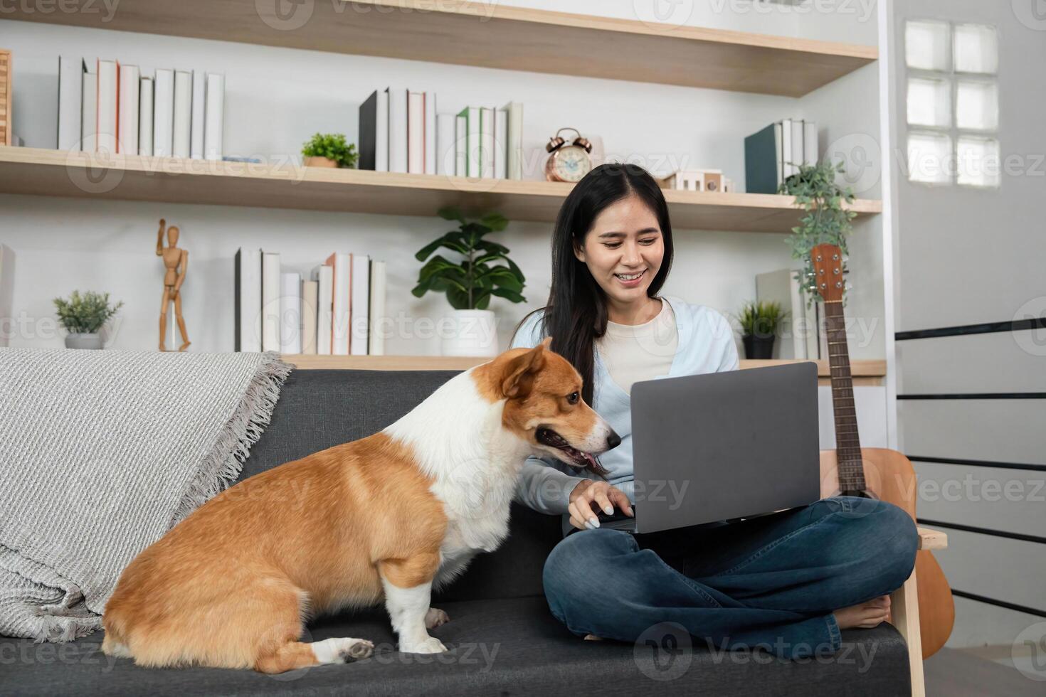 Remote Work and Pet Companionship. Woman enjoying time with dog while using laptop at home. photo