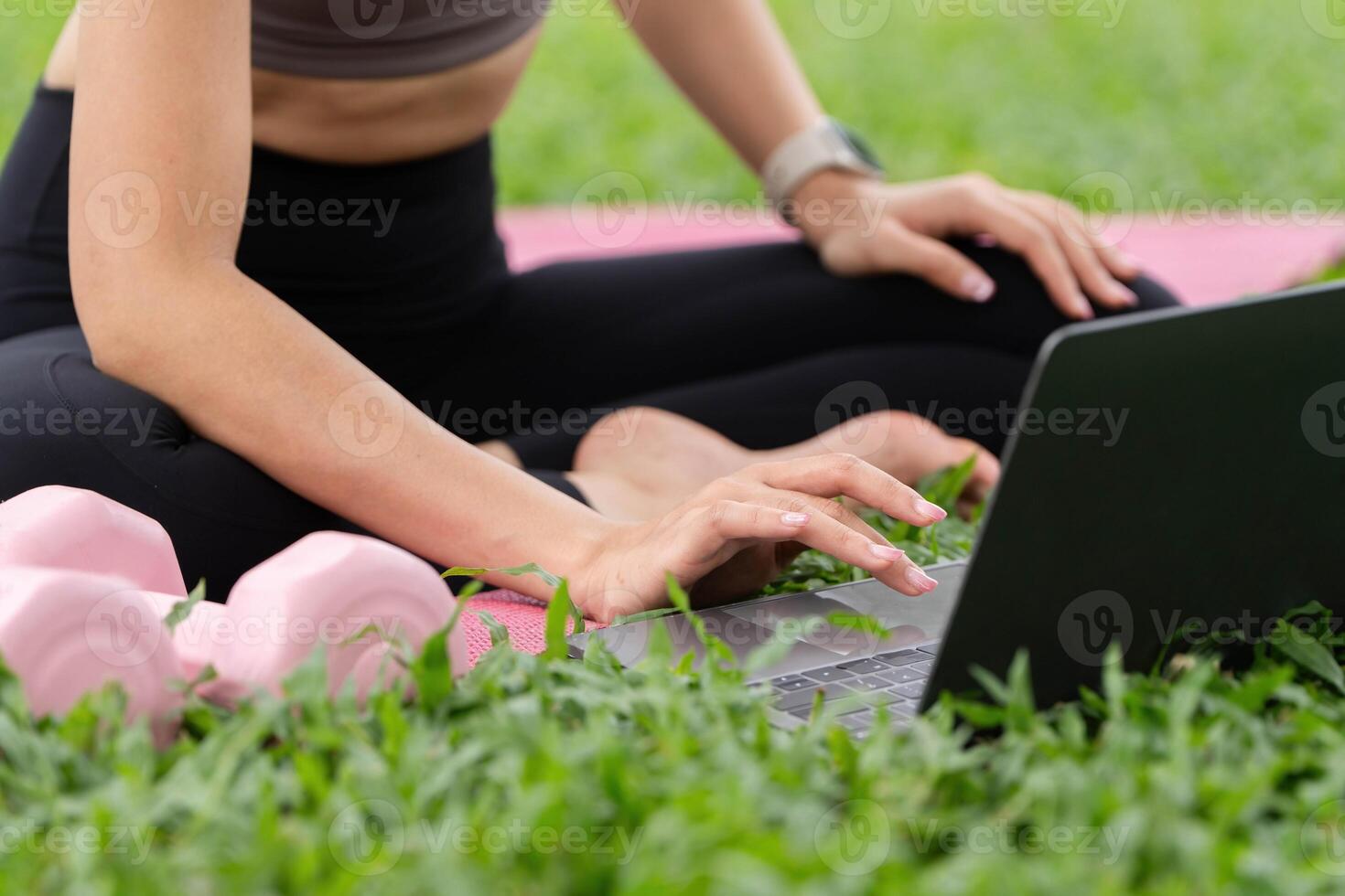Yoga and Productivity. Woman using laptop for fitness while exercising outdoors. photo