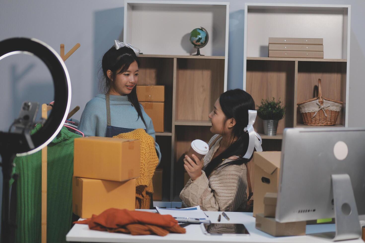 Two women are working in an office with boxes and a computer photo