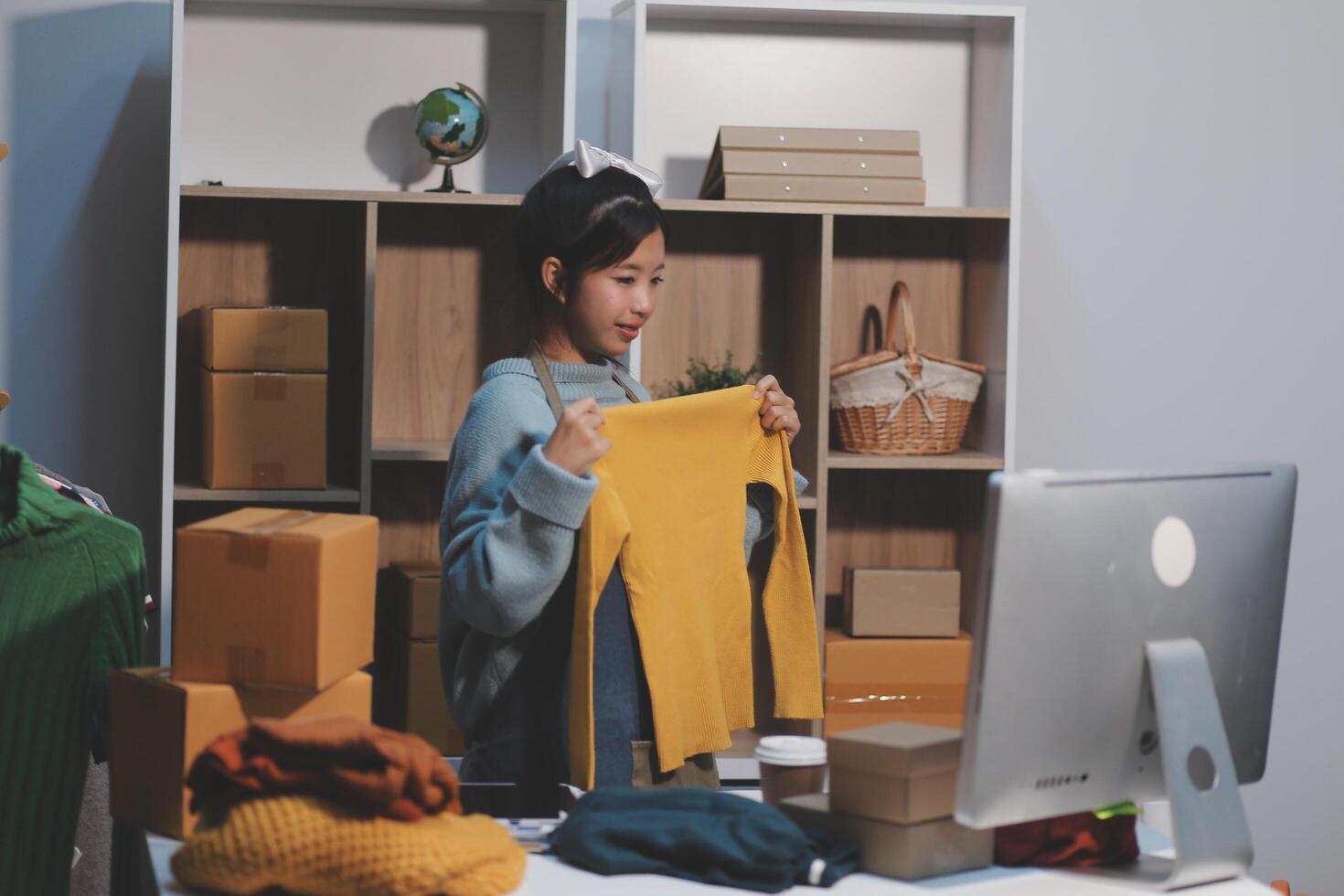 A woman is working on a computer in a room with boxes photo