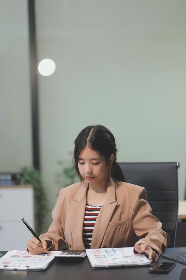 A woman sitting at a desk with a pen and paper photo