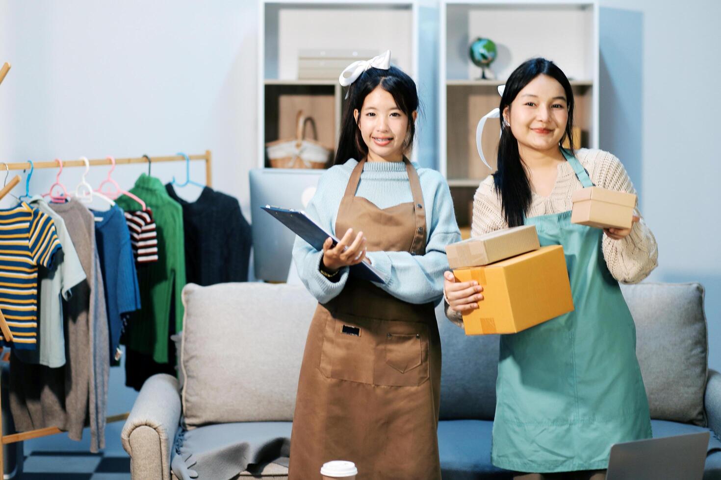 Two women in aprons holding boxes and clothes photo