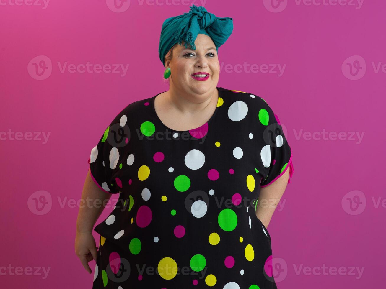 Happy plus size woman smiling in colorful outfit against pink background photo