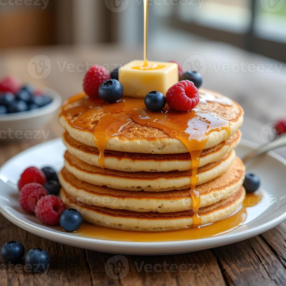 A stack of pancakes with syrup and berries photo