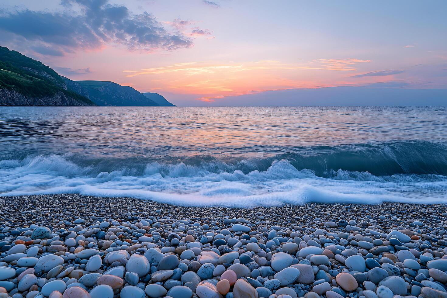 Serene sunset over a pebble beach tranquil waves rolling ashore coastal cliffs photo