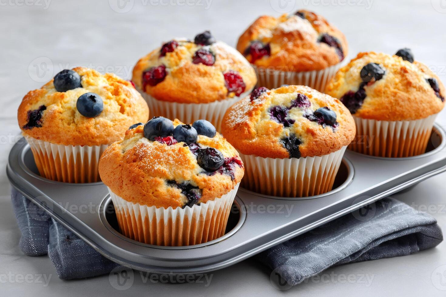 Delicious golden muffins with blueberries and cranberries cooling in a muffin tin photo