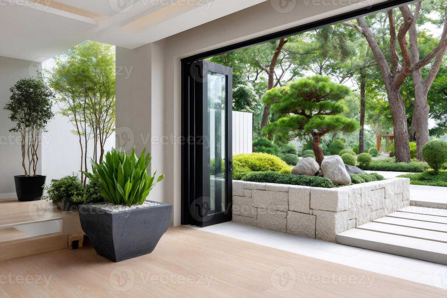 Modern house showing open black frame glass door connecting interior to beautiful green garden photo