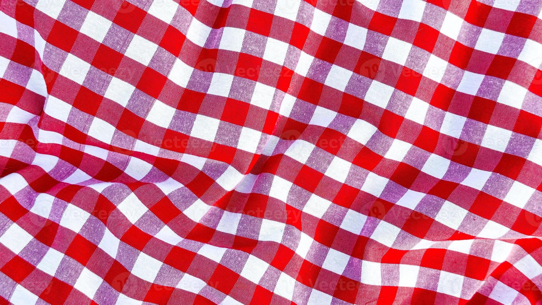 Red and white checkered fabric texture with wavy pattern close up photo