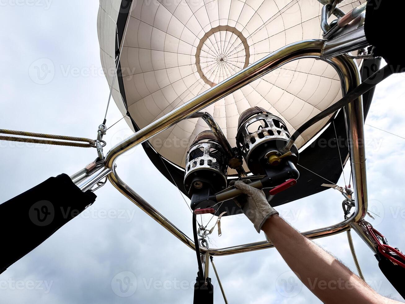 Hot air balloon launch preparation with gloved hand adjusting burners photo