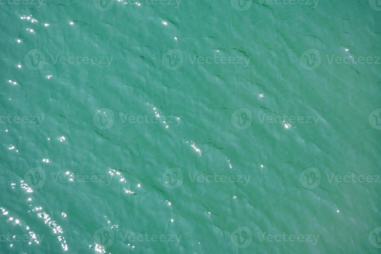 Water surface topview. Sun glare on water. Background abstracted wallpaper texture. photo