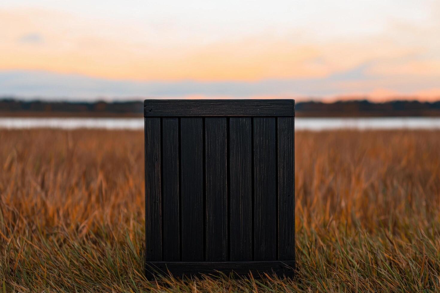 Sunset Landscape A Dark Wooden Box in a Golden Field near a Calm Lake. Peaceful Nature Photography, capturing the serene beauty of photo