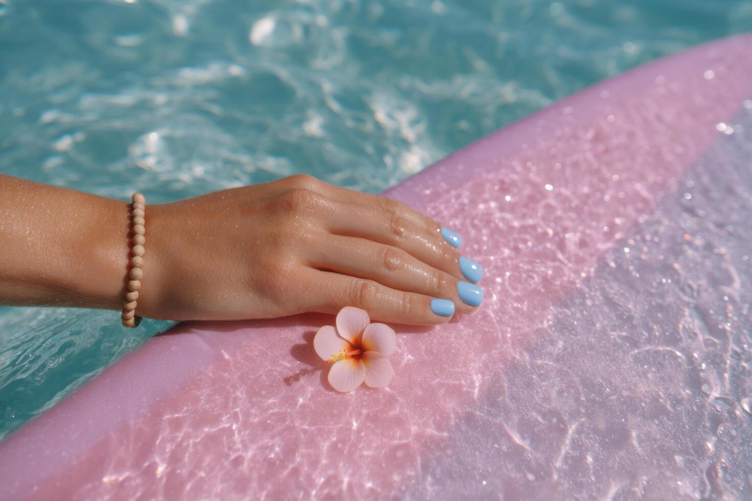 Serene Summer A Woman's Hand with Pastel Nails and a Delicate Flower Resting on a Pink Surfboard by the Pool. A picture of summer photo