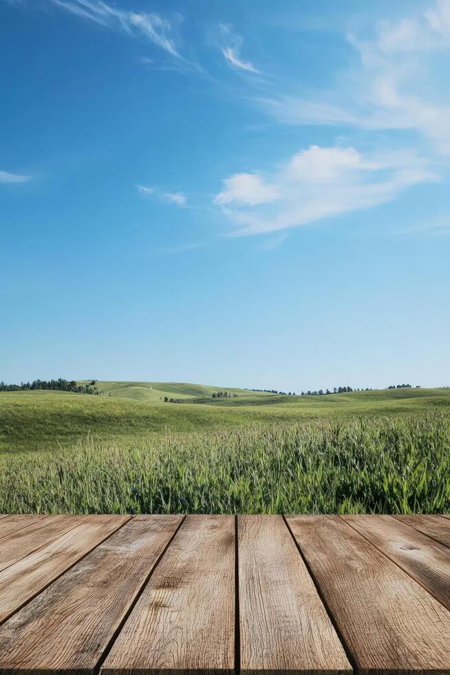 Wooden table overlooks field of grass. Blue sky background for product display photo