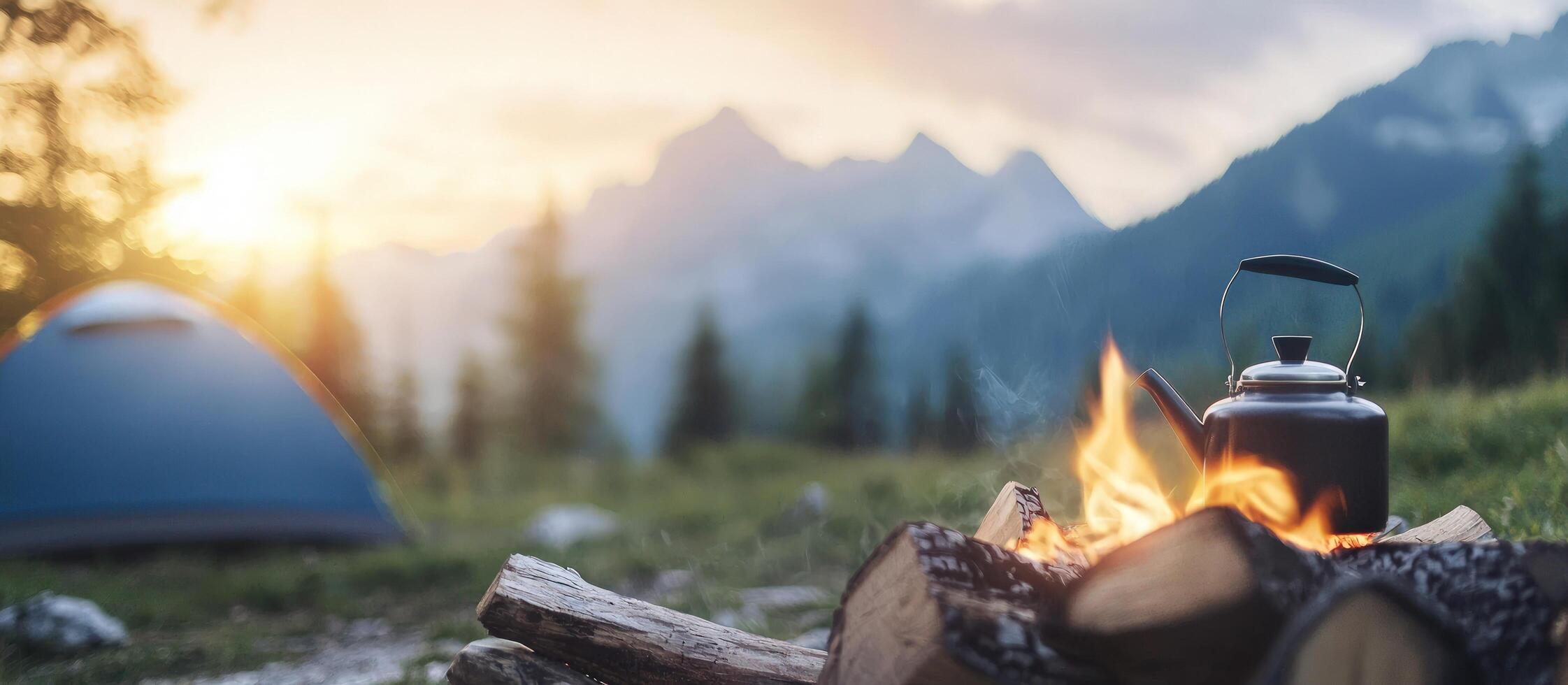 Tent camping with campfire, kettle, and mountains at sunset for travel ads photo