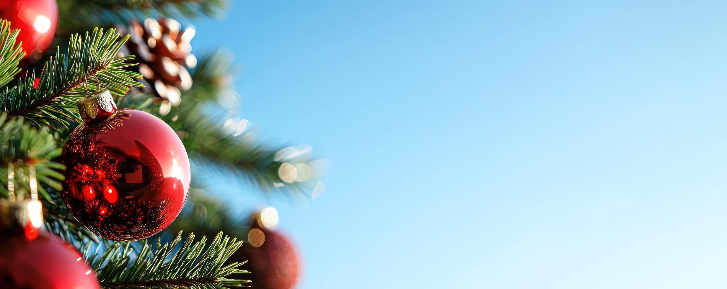 Christmas tree with red ornaments against a clear blue sky photo