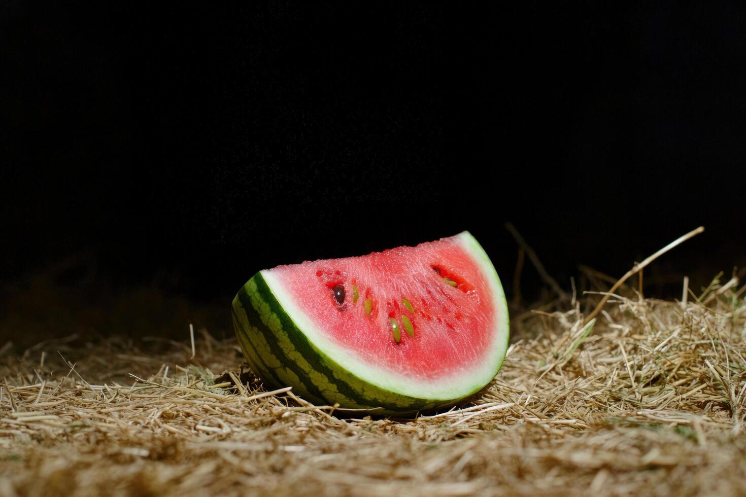 Watermelon slice on hay, dark background, summer vibes, food photography photo