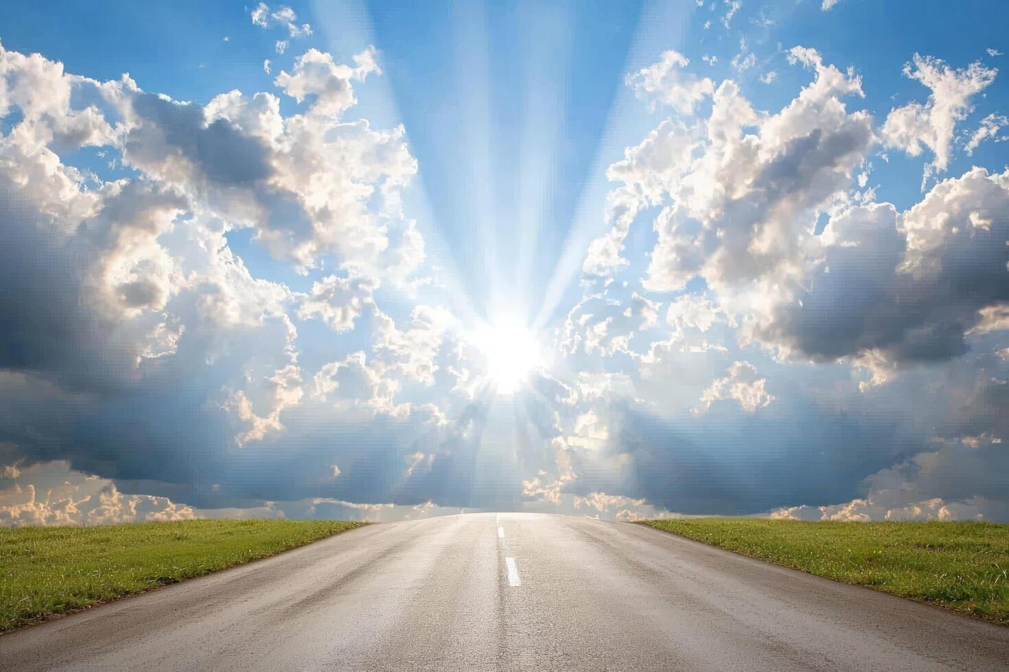 Sunbeams over empty highway road through green fields under dramatic sky photo