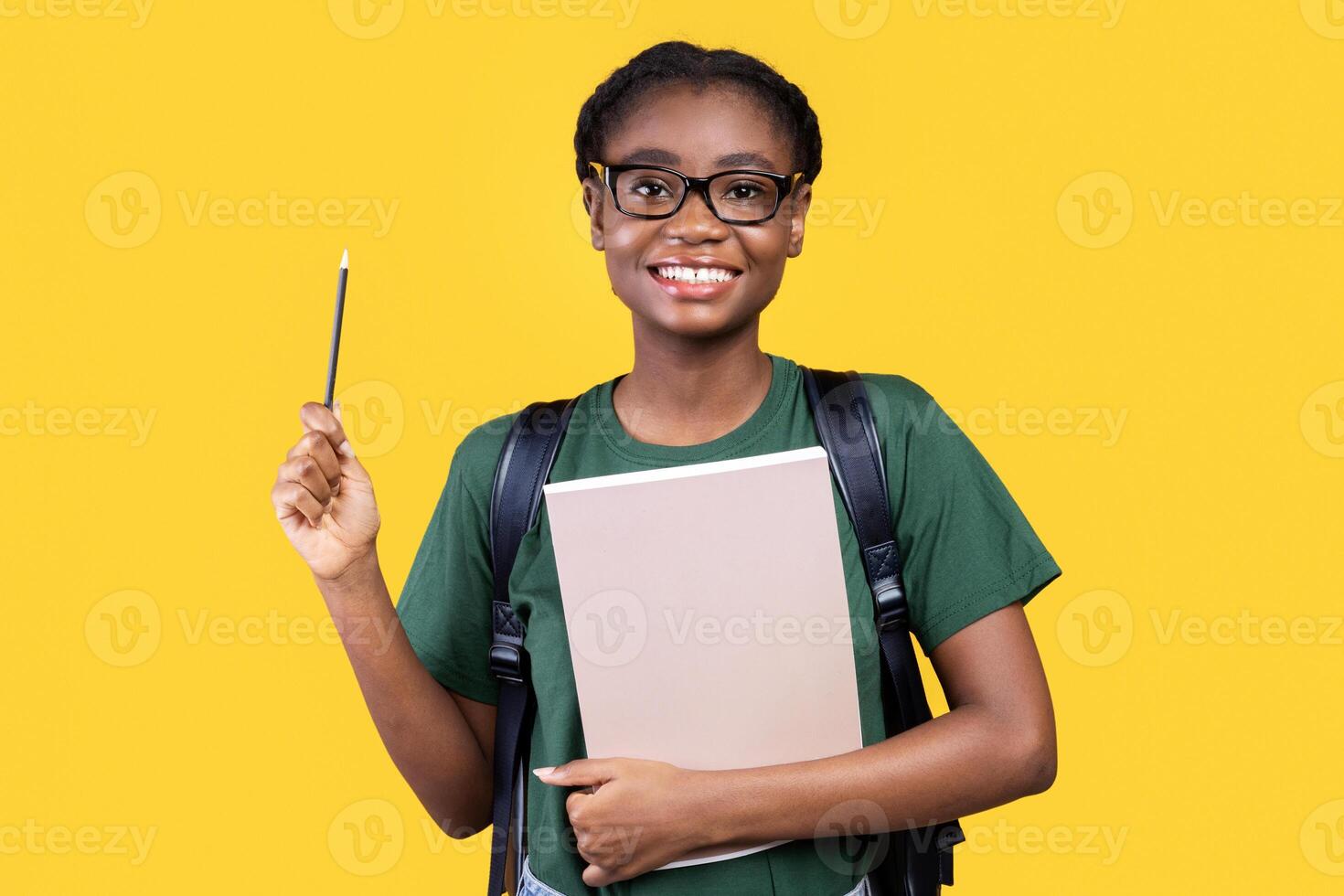 Inspiration. African American Female Student Having Idea Pointing Pencil Up Standing Posing With Books And Notebooks Over Yellow Studio Background. Eureka Moment Concept photo