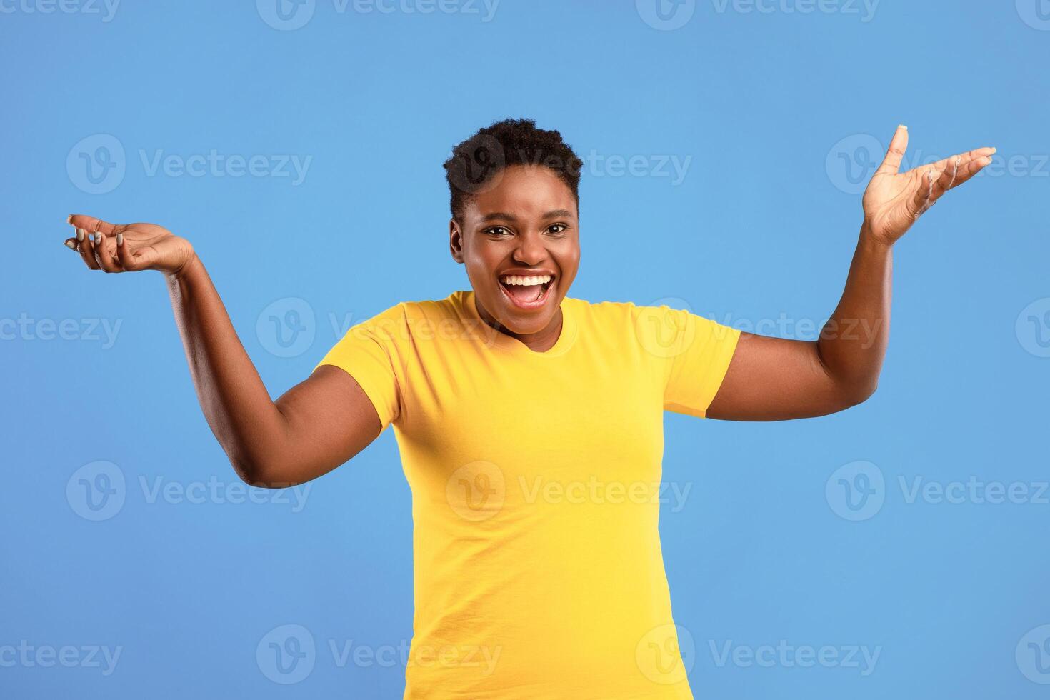 Come On. Joyful African American Plus-Size Woman Gesturing With Raised Hands Urging To Stand Up Standing Posing Over Blue Studio Background, Smiling To Camera. photo