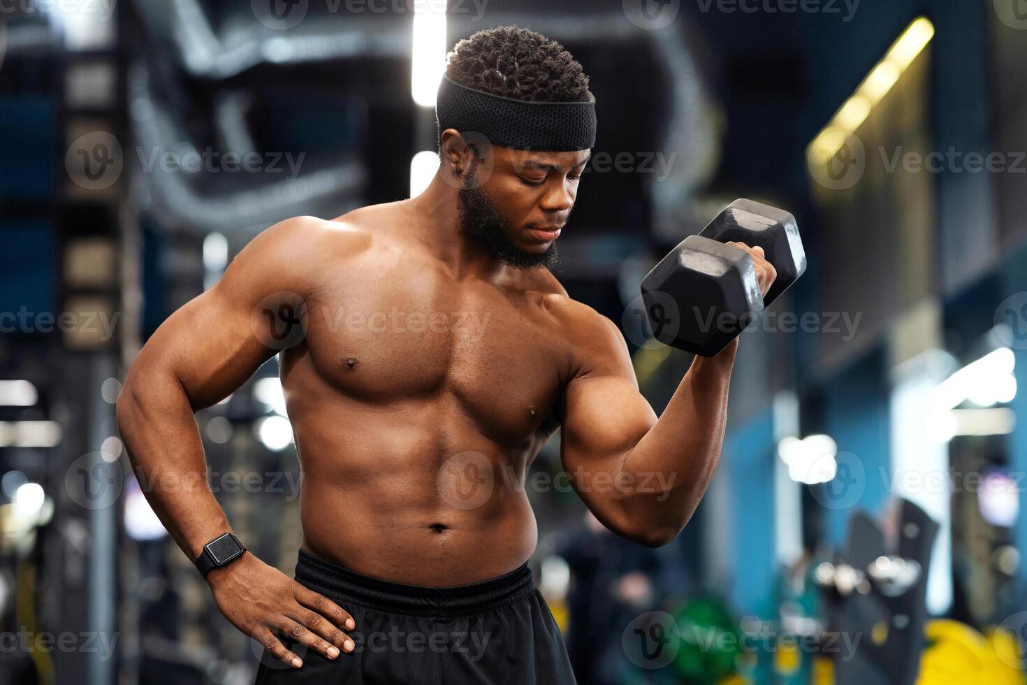 Biceps workout session. Handsome african american shirtless athlete training arms with dumbbells at modern gym, empty space. Hot black bodybuilder working on his biceps, lifting barbell with one hand photo