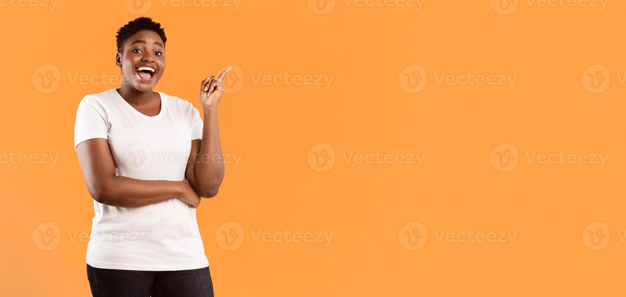 Happy Plus-Size Black Lady Pointing Finger Up Having Great Idea Standing Near Copy Space Advertising Your Text Posing On Yellow Studio Background, Smiling To Camera. Eureka, Inspiration Moment photo