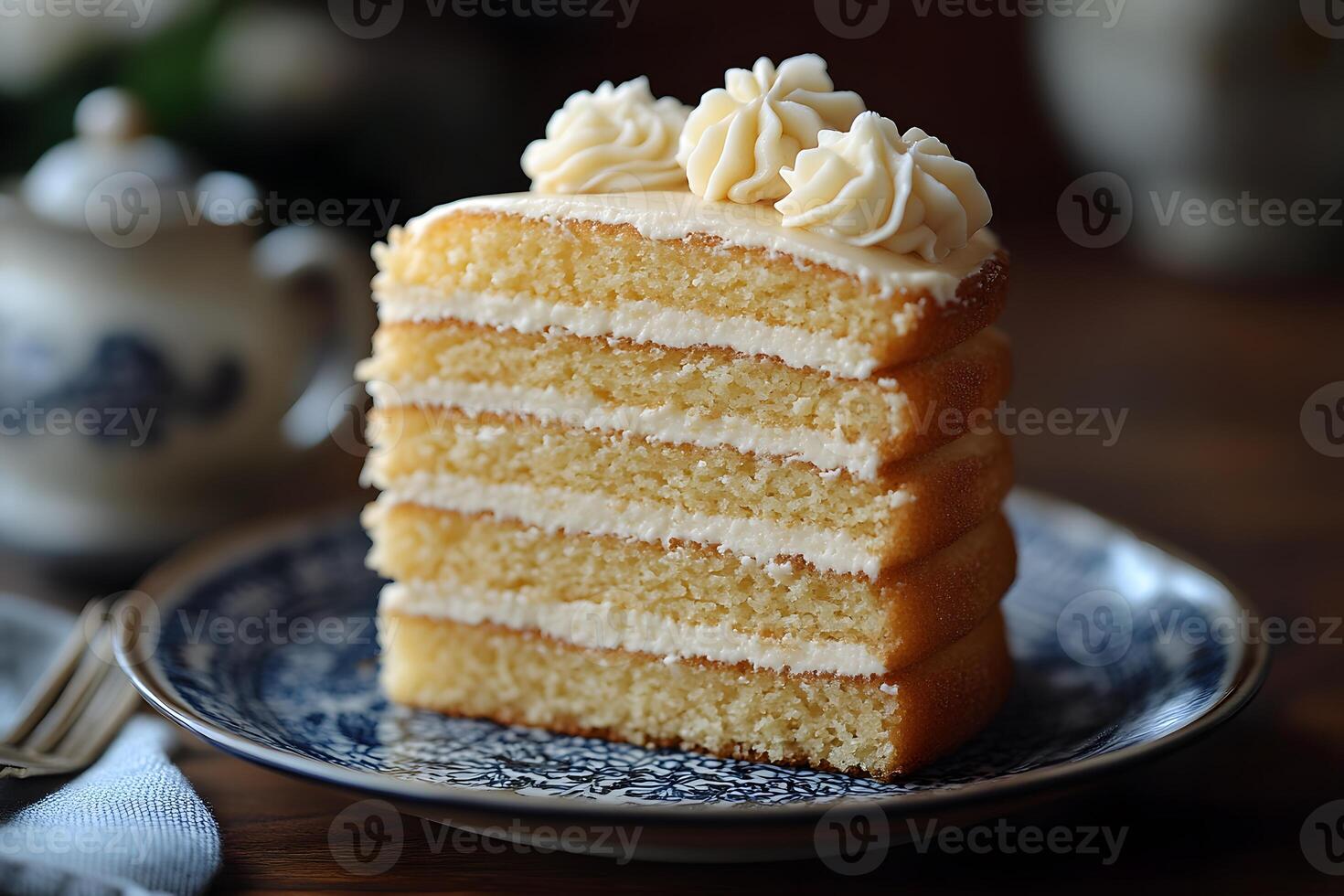 Delicious Slice of Layered Vanilla Cake on Elegant Blue Plate photo