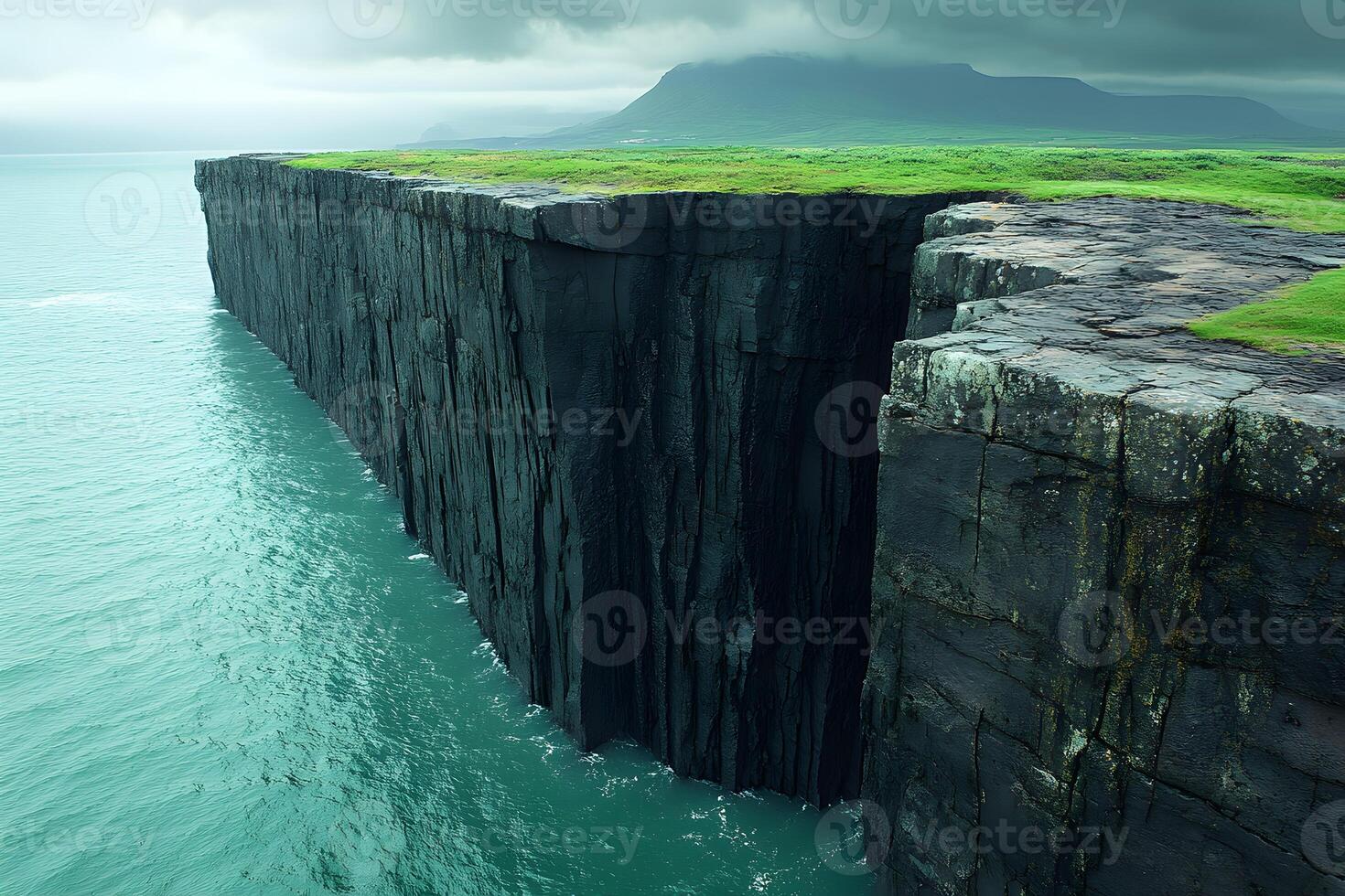 Majestic Coastal Cliff Under Overcast Skies Beside Turquoise Sea Waters photo