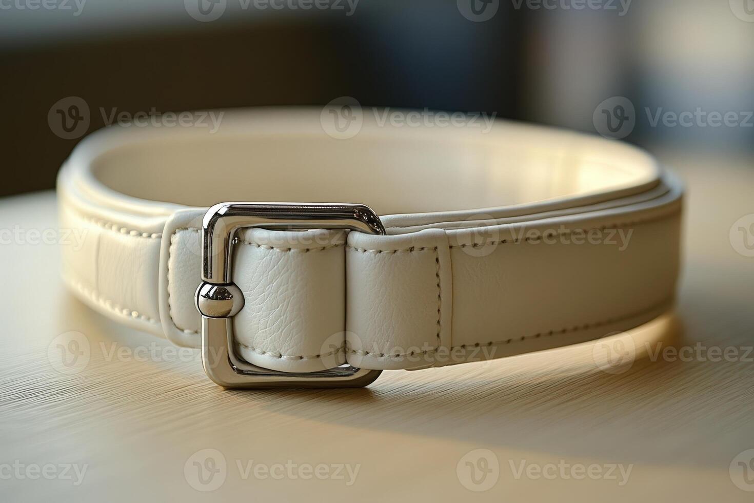 A white leather belt with a silver buckle photo