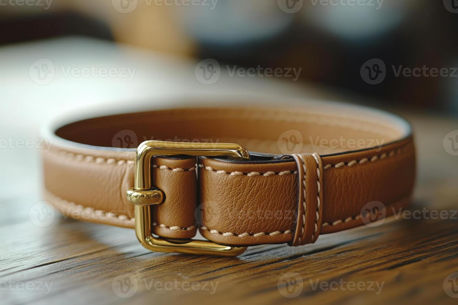 A tan leather dog collar with a gold buckle photo