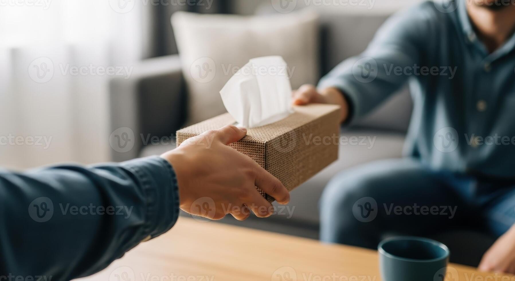 Close up of a hand offering a tissue box, symbolizing comfort and support photo
