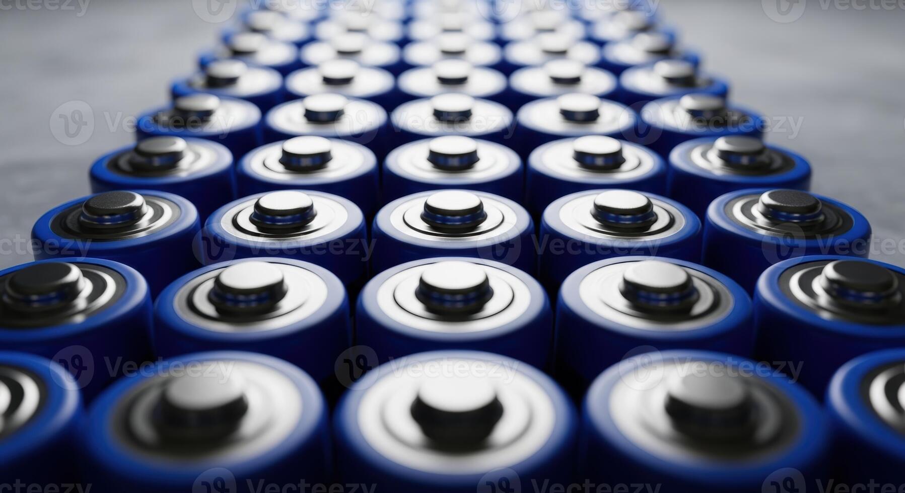 Numerous blue cylindrical batteries with silver tops arranged in parallel rows photo